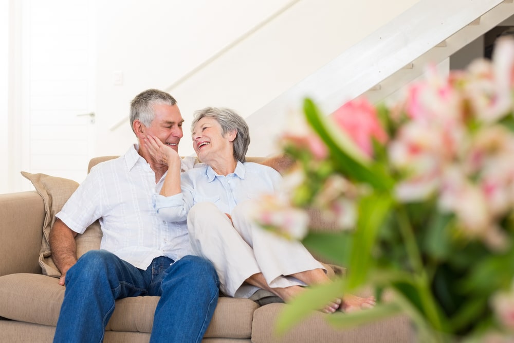 retired couple sitting on a sofa in their homw