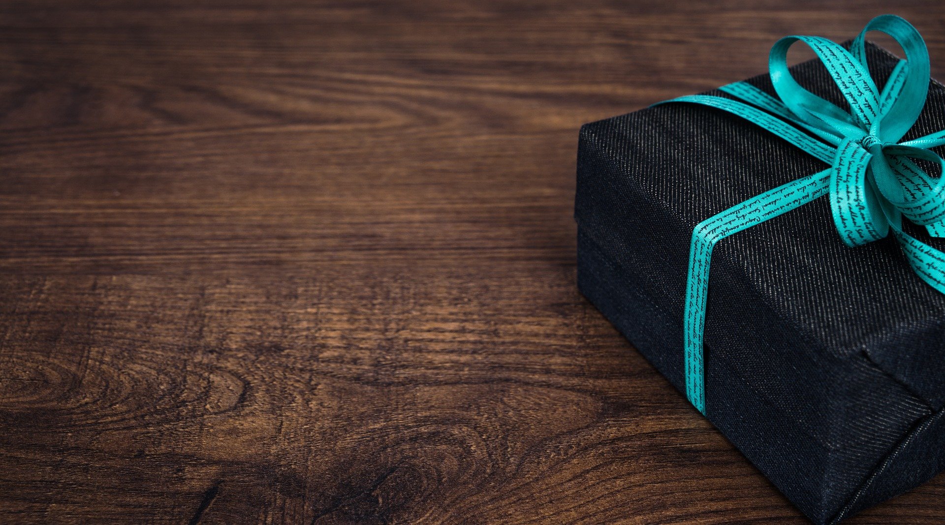 Gift wrapped in black paper with a blue bow representing Gift Tax