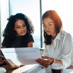 Two young professional woman looking at spreadsheet, representing Tax Planning